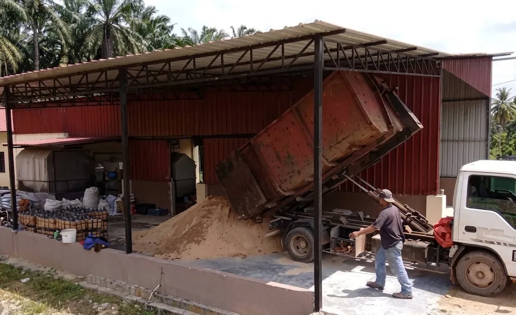 Lori menurunkan habuk kayu di kawasan pemprosesan bongkah.